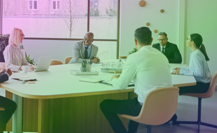 A group of businesspeople talking around a table.
